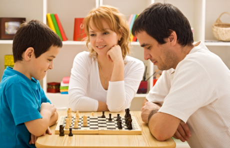 Father and kid playing chess proud mother.png